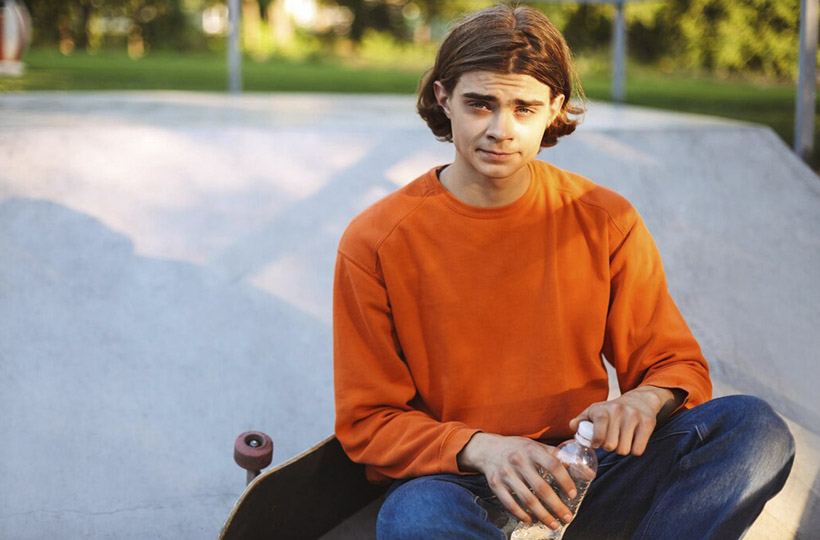 young-skater-orange-pullover-holding-bottle-water-hands-while-dreamily-looking-camera-with-skateboard-skatepark_574295-3402.jpg